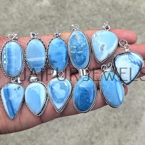 Puede incluir: Una colección de colgantes de ópalo azul claro en varias formas, incluyendo ovalados, de lágrima y de corazón. Cada colgante tiene un marco de metal plateado. Los ópalos muestran una gama de tonos y patrones azules, creando un aspecto único.