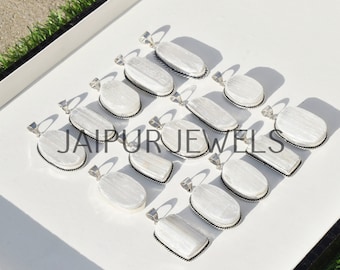 May include: A collection of 12 white selenite crystal pendants with silver-toned bezels and rope-like edges. The pendants are arranged in rows on a white surface.