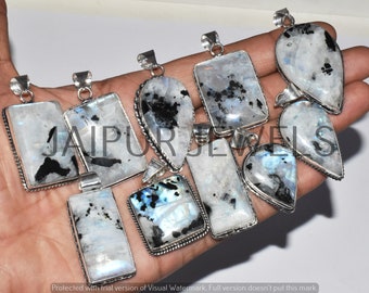 May include: A collection of eight silver pendants with moonstone and black inclusions. The pendants are in various shapes, including rectangular, teardrop, and oval. The pendants are set in silver and have a polished finish.