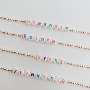 Braccialetti personalizzati in oro con lettere bianche e arcobaleno