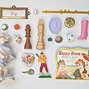 May include: A collection of vintage toys and trinkets, including a wooden chess piece, a ceramic figurine, a dart, a needle book, and a pair of pink doll shoes.