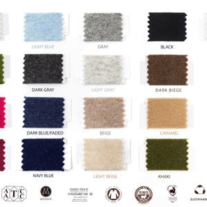 May include: A collection of eighteen rectangular fabric swatches with pinked edges, arranged in a grid. Colors include white, light blue, gray, black, creamy, green, dark gray, light gray, dark beige, pink, dark blue, beige, caramel, wine red, navy blue, light beige, and khaki.