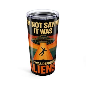 May include: A black and silver travel tumbler with a retro design. The tumbler features the text "I'M NOT SAYING IT WAS, BUT IT WAS DEFINITELY ALIENS" with a graphic of a UFO and a person being beamed up.