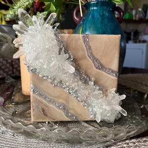 Könnte beinhalten: Eine kleine Holzkiste mit klaren Quarzkristallen, die in Harz eingebettet sind. Die Kiste hat ein natürliches Holzmaserungsmuster und einen silbernen Glitzerakzent.