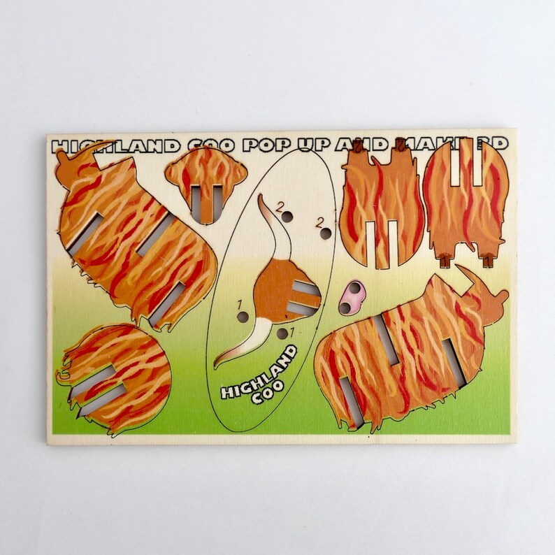 K&ouml;nnte beinhalten: Ein Vintage-Papierbastelset mit einer Highland-Coo, einer schottischen Rinderrasse. Das Set enth&auml;lt verschiedene Teile, um ein 3D-Modell des Tieres zusammenzubauen. Die Teile sind nummeriert und mit Anweisungen zum Zusammenbau beschriftet. Das Set tr&auml;gt den Titel "Highland Coo Pop Up and Make It".
