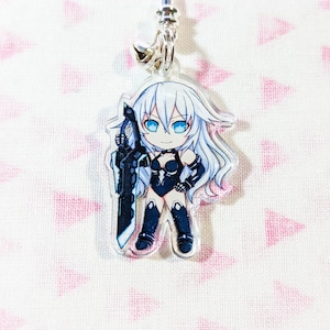 Op de afbeelding: Een heldere acryl bedel met een stripfiguur met wit haar, blauwe ogen en een zwarte outfit, die een groot zwart zwaard vasthoudt. De bedel heeft een zilverkleurige ketting en een belletje.