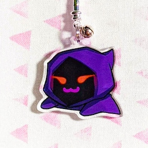 May include: A purple and black cartoon character keychain with a hooded cloak and glowing red eyes. The character has a small, white mustache.
