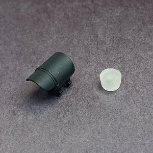 May include: A black plastic camera lens hood and a white plastic lens cap.