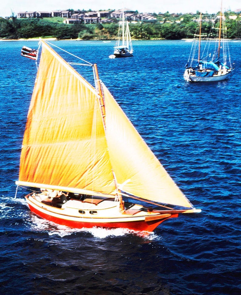 May include: A red and white sailboat with a yellow sail is sailing on a blue body of water. The sailboat is in the foreground of the image, and there are two other sailboats in the background.