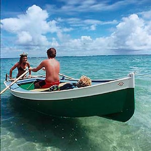 May include: Two people in a green and white wooden rowboat on a clear blue day. The boat is in shallow turquoise water. The sky is blue with white clouds.
