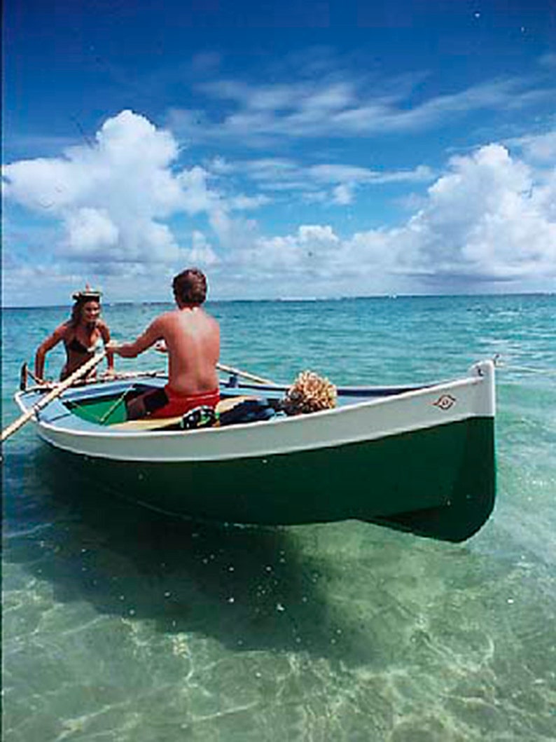 May include: Two people in a green and white wooden rowboat on a clear blue day. The boat is in shallow turquoise water. The sky is blue with white clouds.