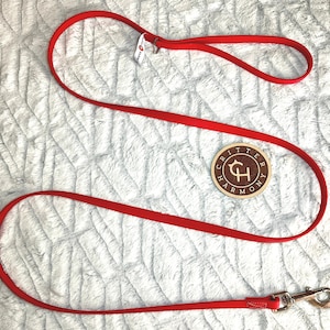 May include: Red dog leash with a metal clip and a wooden tag that says "Critter Harmony" with a stylized "CH" logo.