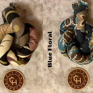 May include: Two knotted dog toys with floral patterns. The toy on the left has a purple floral pattern and the toy on the right has a blue floral pattern. Both toys have a brown leather tag with the text "Critter Harmony" and a stylized "CH" logo.
