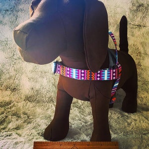 A small beagle model wearing our harness in a 3/4" purple aztec print. This harness slips on over the head and buckles behind the right front leg. Harness is available in many colors, and we use high quality materials and make these in the USA.