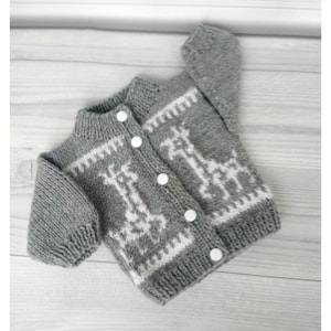 May include: A gray knitted baby cardigan with a white giraffe pattern and white buttons.