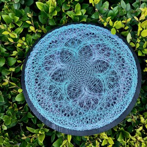 Peut inclure: Une œuvre d'art en fil circulaire avec un effet dégradé bleu et violet. L'art en fil est sur une base en bois noir.