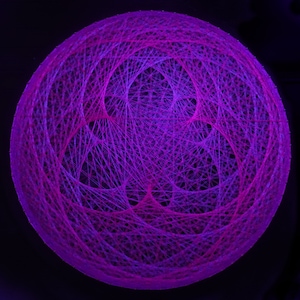 Peut inclure: Une sphère faite de ficelle, avec un motif complexe de fils entrelacés. La sphère est éclairée de l'intérieur, créant un effet lumineux. La ficelle est d'une couleur violette vibrante.