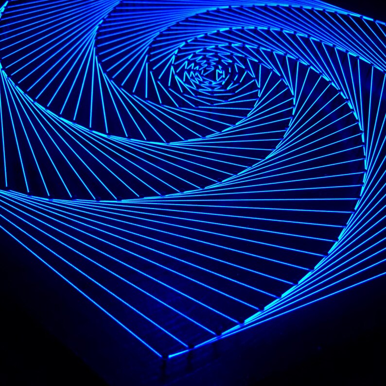 May include: A blue neon light art piece in the shape of a spiral. The light is arranged in a series of lines that create a swirling pattern.
