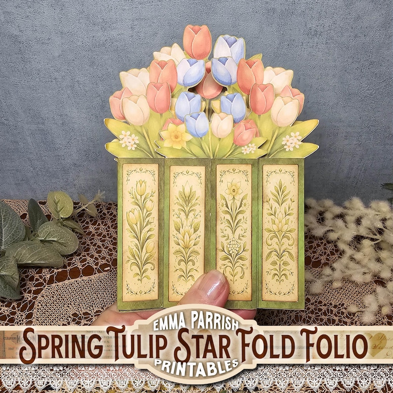 Może przedstawiać: Dekoracyjne papierowe Spring Tulip Star Fold Folio. Folio ma zieloną ramkę z kwiatowymi wzorami i bukiet r&oacute;żowych, brzoskwiniowych i niebieskich tulipan&oacute;w. Widoczny jest tekst "Spring Tulip Star Fold Folio Printables".