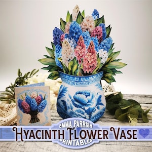 May include: A printable papercraft model of a blue and white porcelain vase with a bouquet of pink, white, and blue hyacinths. The vase has a floral design and the text "Hyacinth Flower Vase" is printed below the vase.
