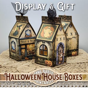 May include: Three Halloween-themed house-shaped boxes with vintage-style illustrations. The boxes feature images of a witch, a ghost, and a spooky door. The text "Trick & Treat" is visible on the boxes. The boxes are displayed on a lace tablecloth.