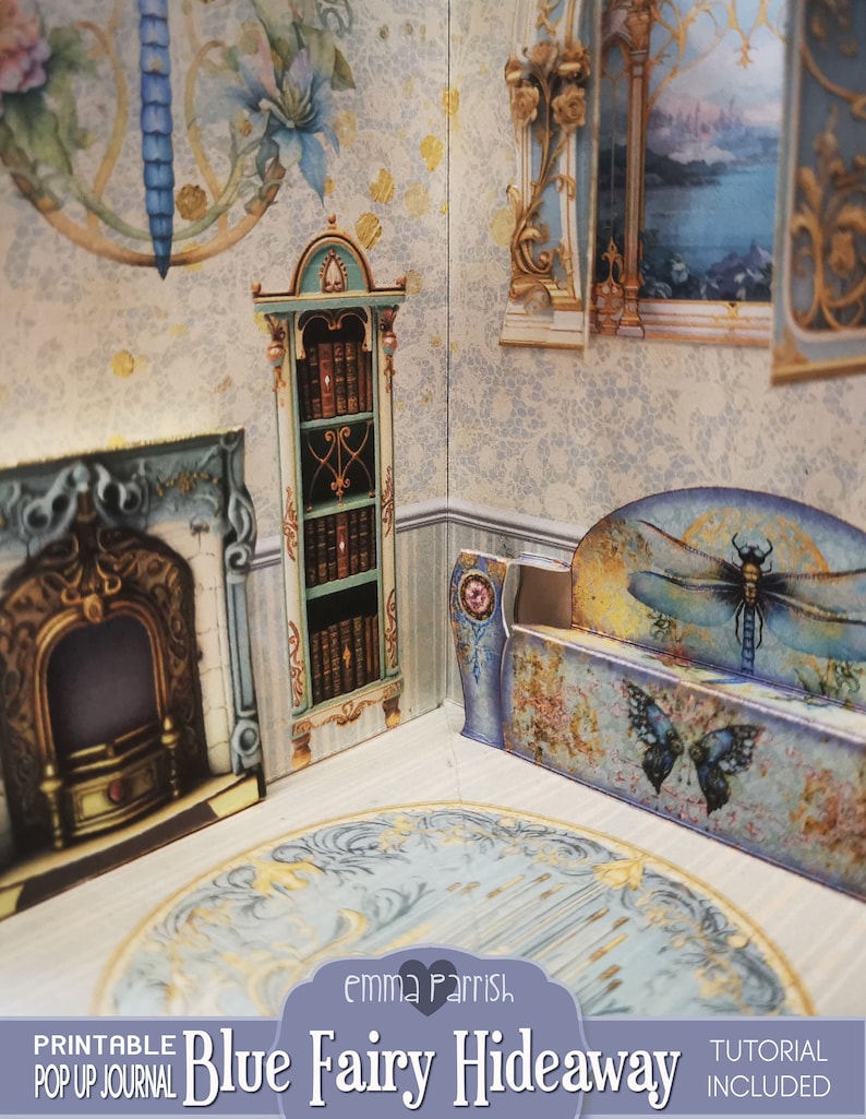 Puede incluir: Un diario desplegable imprimible titulado "Blue Fairy Hideaway" con un tutorial incluido. El diario presenta un dise&ntilde;o de tem&aacute;tica de hadas caprichoso con una combinaci&oacute;n de colores azul y dorado. La imagen muestra una escena desplegable en 3D de una habitaci&oacute;n con una chimenea, una estanter&iacute;a y un banco.