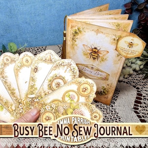Peut inclure: Un journal à couverture crème orné d'une illustration d'abeille et du texte Busy Bee, accompagné de plusieurs étiquettes décoratives à motifs floraux et d'abeilles. Une étiquette hexagonale attachée au journal porte l'inscription Honey Bee.