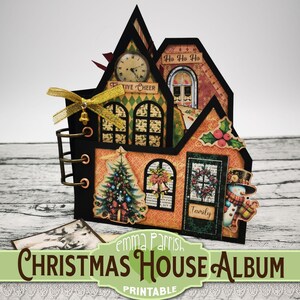 May include: A printable Christmas house album with a festive design. The album is decorated with a Christmas tree, a snowman, and a wreath. The album is titled "Christmas House Album" and has the text "Emma Parrish" and "Printable" on it.