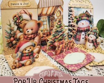 May include: Three decorative paper gift tags featuring Christmas themes. One tag shows teddy bears with the text Peace & Joy, another depicts a cozy room with a tree, and the third displays snowmen with the text Jolly Greetings. Each tag includes pop-up elements.