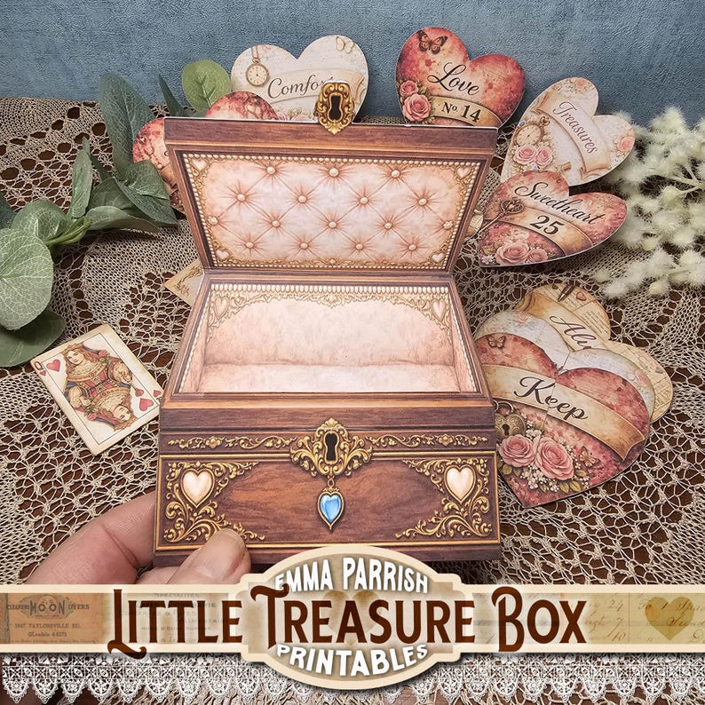 May include: A miniature wooden treasure box with an open lid, featuring ornate gold detailing and a blue gem. Heart-shaped cards with floral and text designs surround the box. The text "Little Treasure Box Printables" is displayed at the bottom.