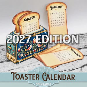 May include: A blue metal toaster-shaped calendar holder with floral and bird motifs, displaying the year 2027. It includes several bread-shaped calendar cards for January, February, and March, featuring printed dates and the text 2027 EDITION.