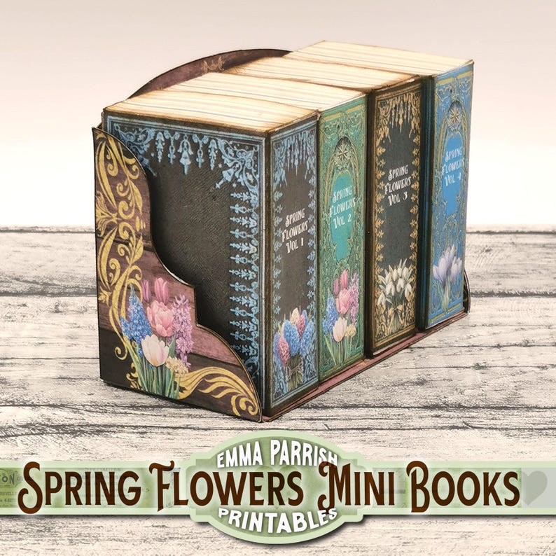 May include: Three miniature books with floral designs and the title "Spring Flowers Vol. 1", "Spring Flowers Vol. 2", and "Spring Flowers Vol. 3" on their spines. The books are arranged in a wooden stand with a decorative floral design.