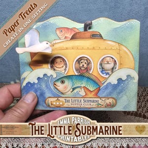 Può includere: Un'artigianato di carta stravagante con un sottomarino giallo con oblò che mostrano un bambino, un cane e un uomo. Sono raffigurati anche un gabbiano e un pesce. Il testo "Paper Treats" e "The Little Submarine Supper Club" sono visibili.