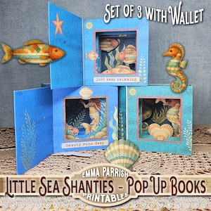 Könnte beinhalten: Set aus drei blauen Pop-up-Büchern mit Illustrationen zum Thema Meer. Jedes Buch zeigt eine andere Unterwasserszene mit Fischen, Seepferdchen und Meerjungfrauen. Der Text "just keep swimming" und "beauty runs deep" ist sichtbar. Enthält ein Portemonnaie.