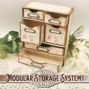 May include: A vintage-style modular storage system with drawers featuring a floral pattern. The drawers have labels and brass-colored hardware. The system is made of cardboard and is labeled "Emma Parrish Modular Storage System Printables".