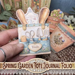 May include: A paper craft journal folio with a spring garden theme. The main element is a blue and beige tote bag with garden tools, including scissors, a trowel, and a fork. The text "Tools" is on the front. Other elements include a thermometer and flower pots.