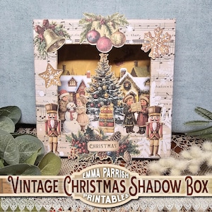 Könnte beinhalten: Eine Vintage-Weihnachtsschattenschatulle mit einer Winterszene, die einen Weihnachtsbaum, Kinder und einen Schneemann zeigt. Die Schachtel ist mit Glocken, Ornamenten und einem Stern verziert. Der Text "CHRISTMAS" ist sichtbar.