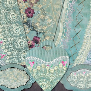 May include: A set of three vintage-style decorative labels with a blue background and white lace trim. The labels are shaped like a heart and two ovals. The heart label has a floral design with pink flowers. The oval labels have a floral design with white flowers.