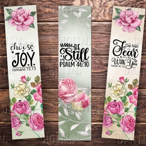 May include: Three floral bookmark designs with inspirational quotes. The first bookmark features a pink rose and the quote "choose joy romans 15.13". The second bookmark features a pink rose and the quote "be still psalm 46:10". The third bookmark features a pink rose and the quote "do not fear for i am with you isaiah 41:10".