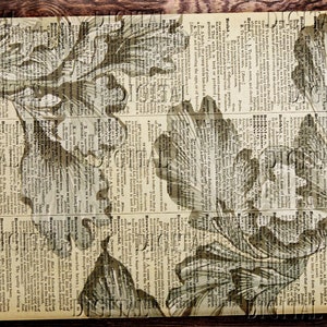 May include: A vintage book page with a floral pattern printed on it. The flowers are in shades of brown and white and are printed over the text of the book page.