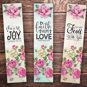 May include: Three bookmarks with floral designs and inspirational quotes. The first bookmark features a pink rose design and the quote "choose JOY romans 15.13". The second bookmark features a blue and white floral design and the quote "faith hope love 1 Corinthians 13:13". The third bookmark features a cream and pink floral design and the quote "Do Not Fear For I Am With You Isaiah 41:10".