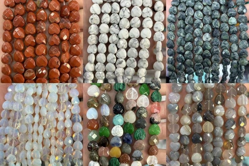 May include: Assortment of heart-shaped gemstone beads in various colors, including orange, white, green, and gray. The beads are strung together, showcasing their faceted surfaces and natural variations. Ideal for jewelry making.
