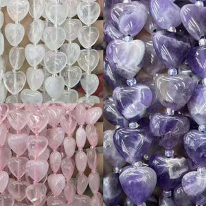 May include: Four strands of heart-shaped gemstone beads in clear, pink, and purple hues. The beads are strung together, creating a textured, decorative element. The gemstones have a polished finish and are connected by small, clear beads.