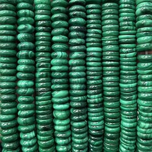 Op de afbeelding: Rijen gepolijste, groene malachietarmbanden. Elke armband heeft een levendige groene tint met donkere, wervelende patronen. De armbanden zijn dicht op elkaar gestapeld, waardoor een dichte, getextureerde weergave van natuurstenen sieraden ontstaat.