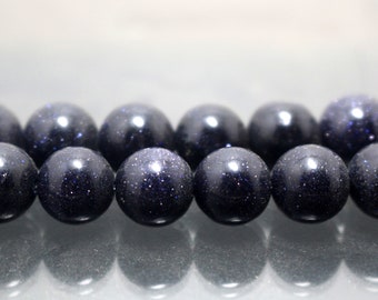 May include: A strand of dark blue gemstone beads with a sparkly, speckled texture. The beads are round and smooth, and they are arranged in a row.