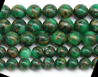 Puede incluir: Una hebra de cuentas redondas verdes y doradas. Las cuentas están hechas de un material translúcido con un patrón de mármol.