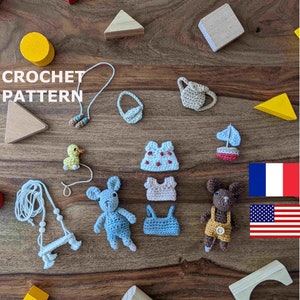 Puede incluir: Patrón de crochet para una variedad de pequeños juguetes amigurumi, incluyendo un ratón, un pato, un barco, una regadera, un vestido, una blusa y una bolsa. El patrón está disponible en inglés y francés. La imagen también incluye bloques de madera y un triángulo amarillo.