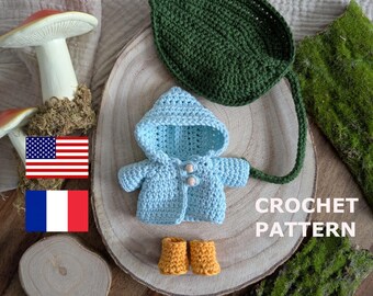 May include: Crochet pattern for a blue hooded jacket with a green leaf and boots. The pattern is available in English and French.