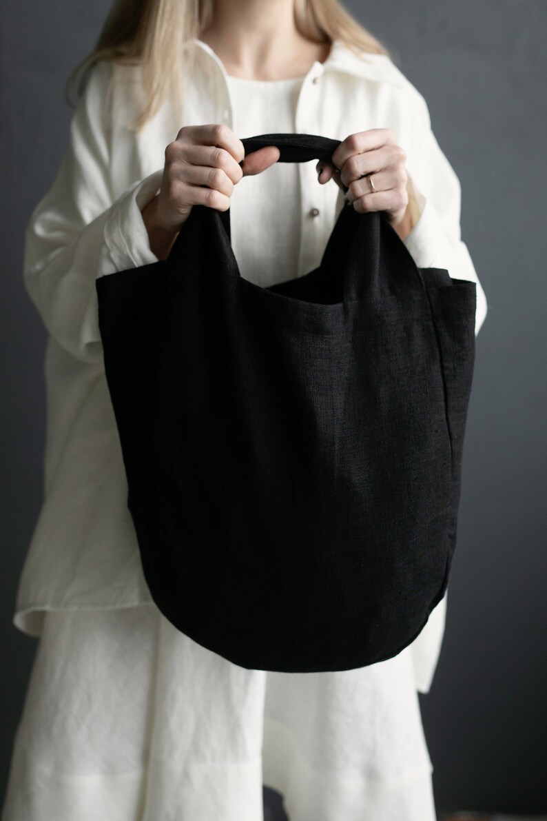 a woman holding a black bag in her hands