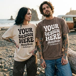 May include: Two people wearing t-shirts with the text "YOUR DESIGN HERE" in a bold, retro font. The shirts are beige and brown. The text "MoxxyMocks + Vibes That Standout" is below the main text. The background is a beach scene.